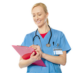 Image showing Portrait of happy senior doctor writing on clipboard