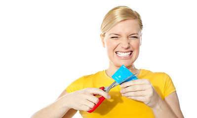 Image showing Woman grinding teeth while cutting her credit card