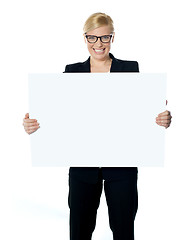 Image showing Attractive businesswoman holding blank advertising board