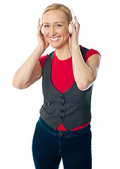 Image showing Aged female enjoying music on her music player