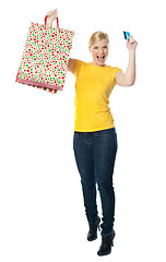 Image showing Excited teenager holding shopping bag and card