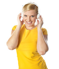 Image showing Smiling young lady listening music