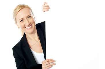 Image showing Smiling aged female executive holding clipboard