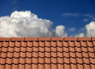 Image showing Roof tiles and blue sky with clouds