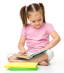 Image showing Cute little girl reads a book