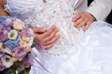 Image showing hands of groom gently embracing brides's waist