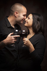 Image showing Happy Mixed Race Couple Flirting and Holding Wine Glasses