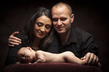 Image showing Mixed Race Couple Lovingly Look On While Baby Lays on Pillow