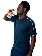 Image showing Tired african athlete drinking water