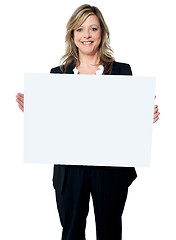 Image showing Smiling woman holding a blank billboard