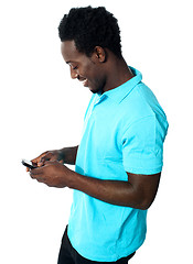 Image showing African boy busy messaging