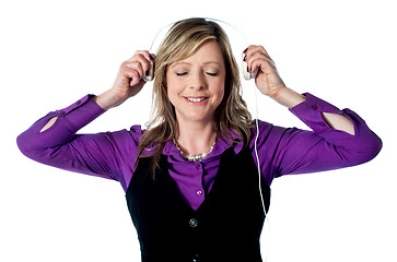 Image showing Lady enjoying music through headphones