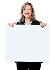 Image showing Female business professional holding blank billboard