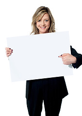 Image showing Beautiful woman pointing at the blank billboard