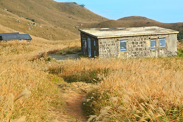 Image showing old stone house with grass on the mountain 