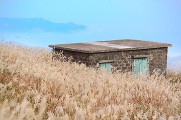 Image showing old stone house with grass on the mountain 