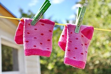 Image showing Pink baby sock hanging on the clothesline