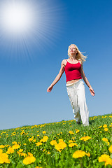 Image showing young woman in red outfit having fun on meadow