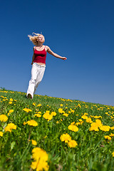 Image showing young woman in red outfit having fun on meadow