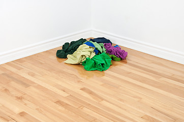 Image showing Pile of colorful clothes in the room corner