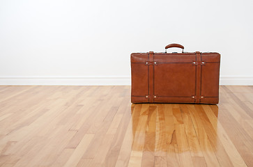 Image showing Retro leather suitcase on wooden floor