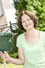 Image showing Senior woman holding rake