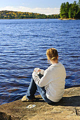 Image showing Woman relaxing at beautiful lake