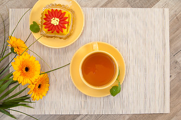 Image showing tea with cake and gerberas flowers
