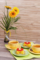 Image showing tea with cake and gerberas flowers