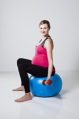 Image showing Pregnant woman exercising with dumbbells