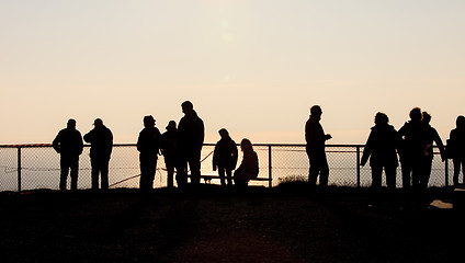 Image showing Silhouettes of people at the fence