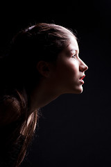 Image showing young girl lasting forward to light on black