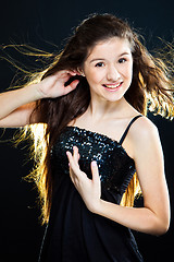 Image showing teenager girl showing  beautiful healthy long dark hair  on black