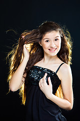 Image showing teenager girl showing  beautiful healthy long dark hair  on black