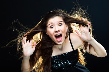 Image showing cute girl with dark long hair shouting on black