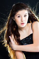 Image showing cute teenager girl with  beautiful long dark hair  on black