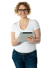 Image showing Senior woman holding tablet, smiling