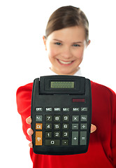 Image showing Smiling school girl showing digital calculator