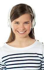 Image showing Closeup of a smiling beauty enjoying music