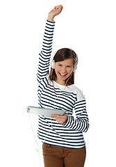 Image showing Trendy young girl enjoying music with raised arm