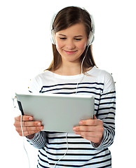 Image showing Pretty young girl enjoys listening music