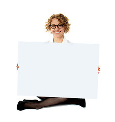 Image showing Female employee holding white blank banner ad