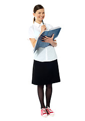 Image showing School girl thinking and smiling at camera