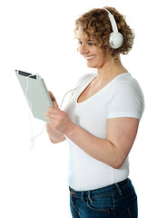 Image showing Woman listening to music on her i-pad