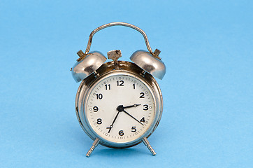 Image showing Retro grunge rusty alarm clock blue background 