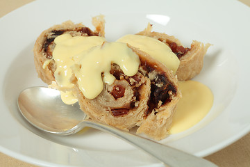 Image showing Spotted dick with custard and spoon