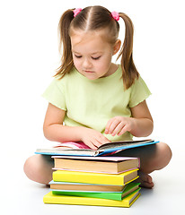 Image showing Cute little girl reads a book