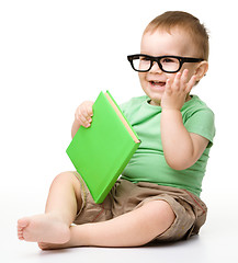 Image showing Little child play with book