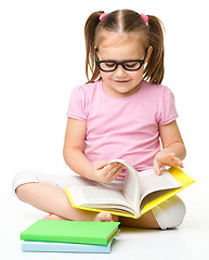 Image showing Cute little girl reads a book