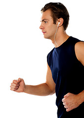 Image showing Fit athlete enjoying music in a jogging posture